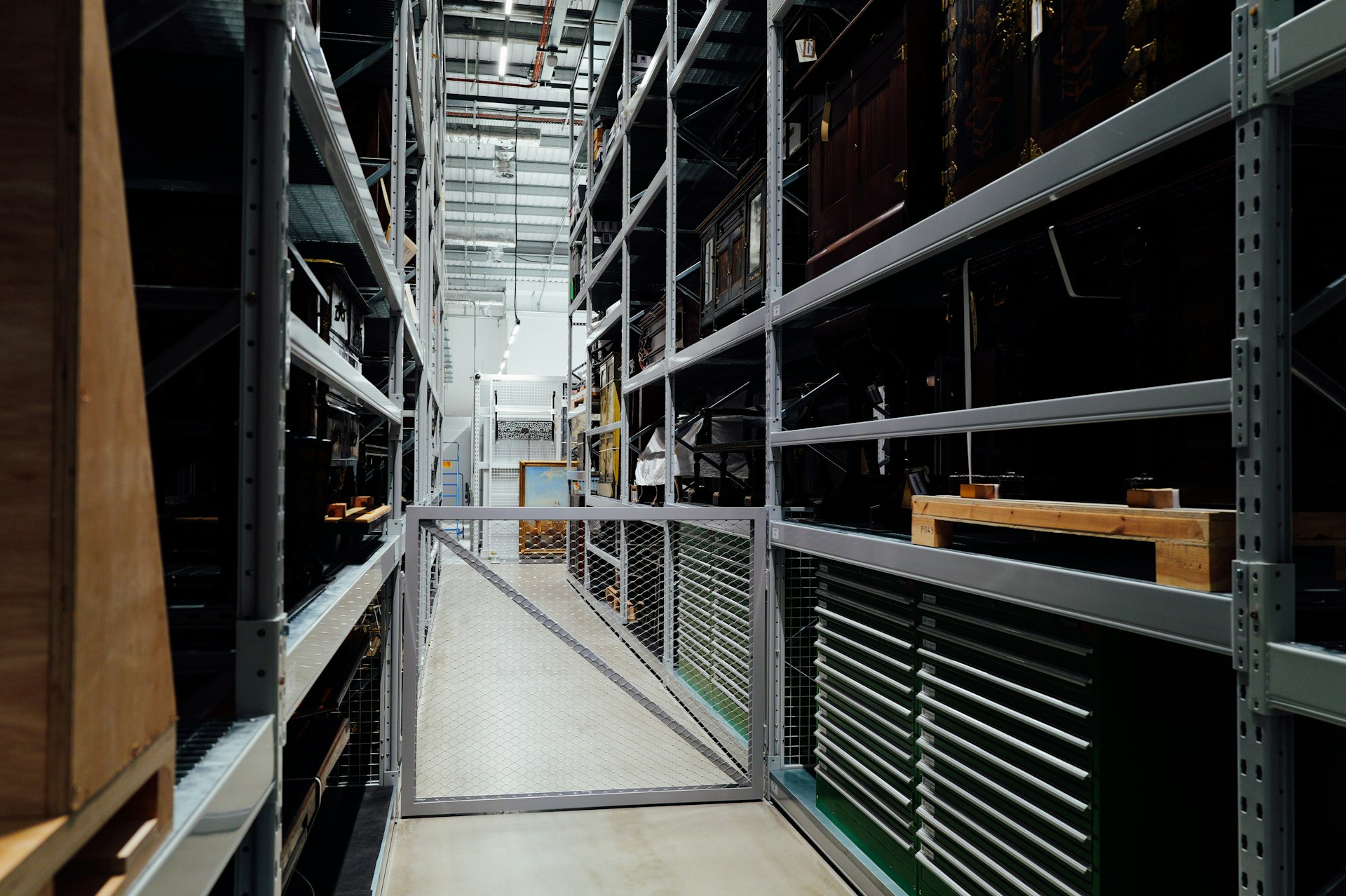 A long aisle between tall storage shelves in a warehouse