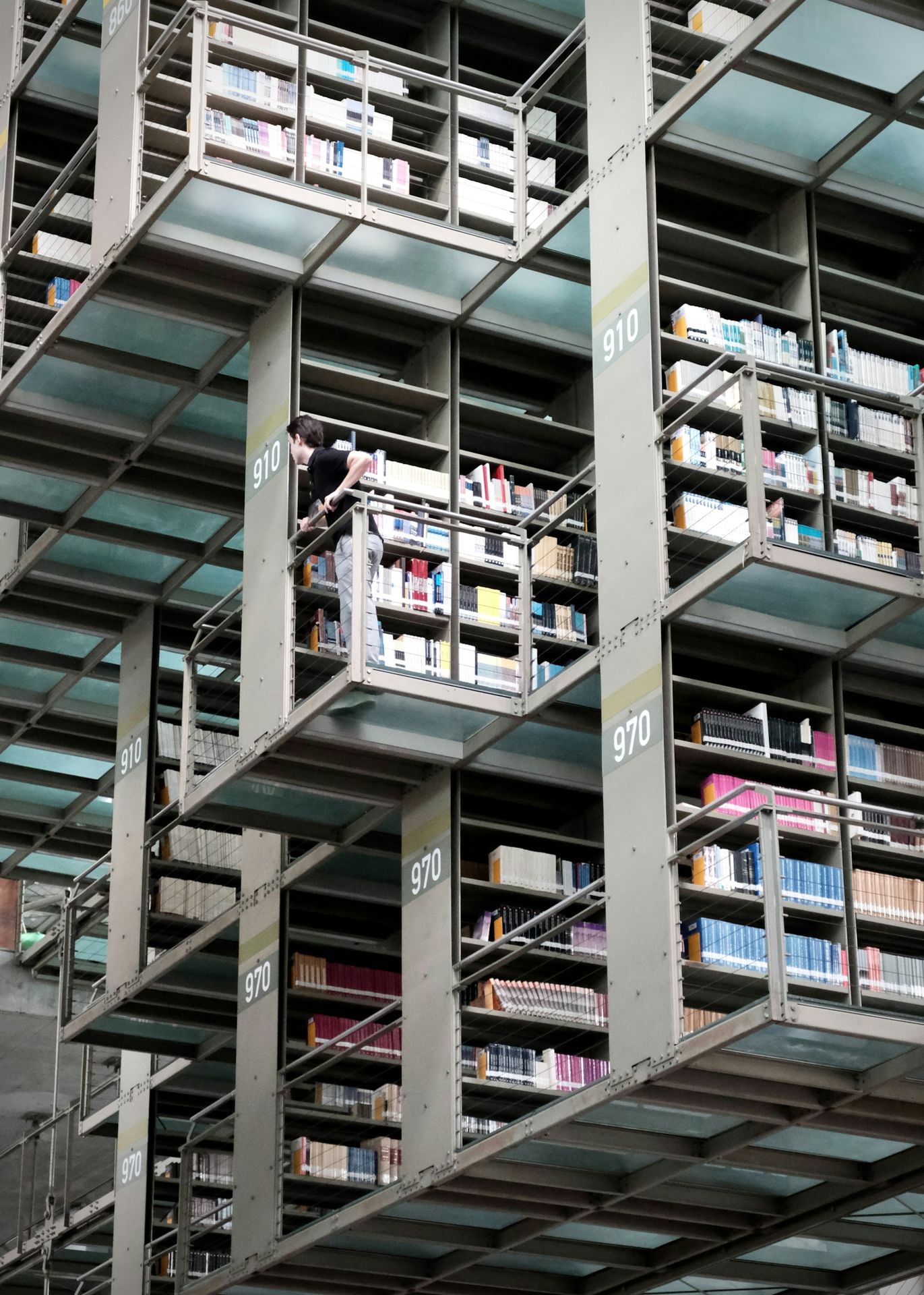 Modern library with multi-level bookshelves and glass walkways