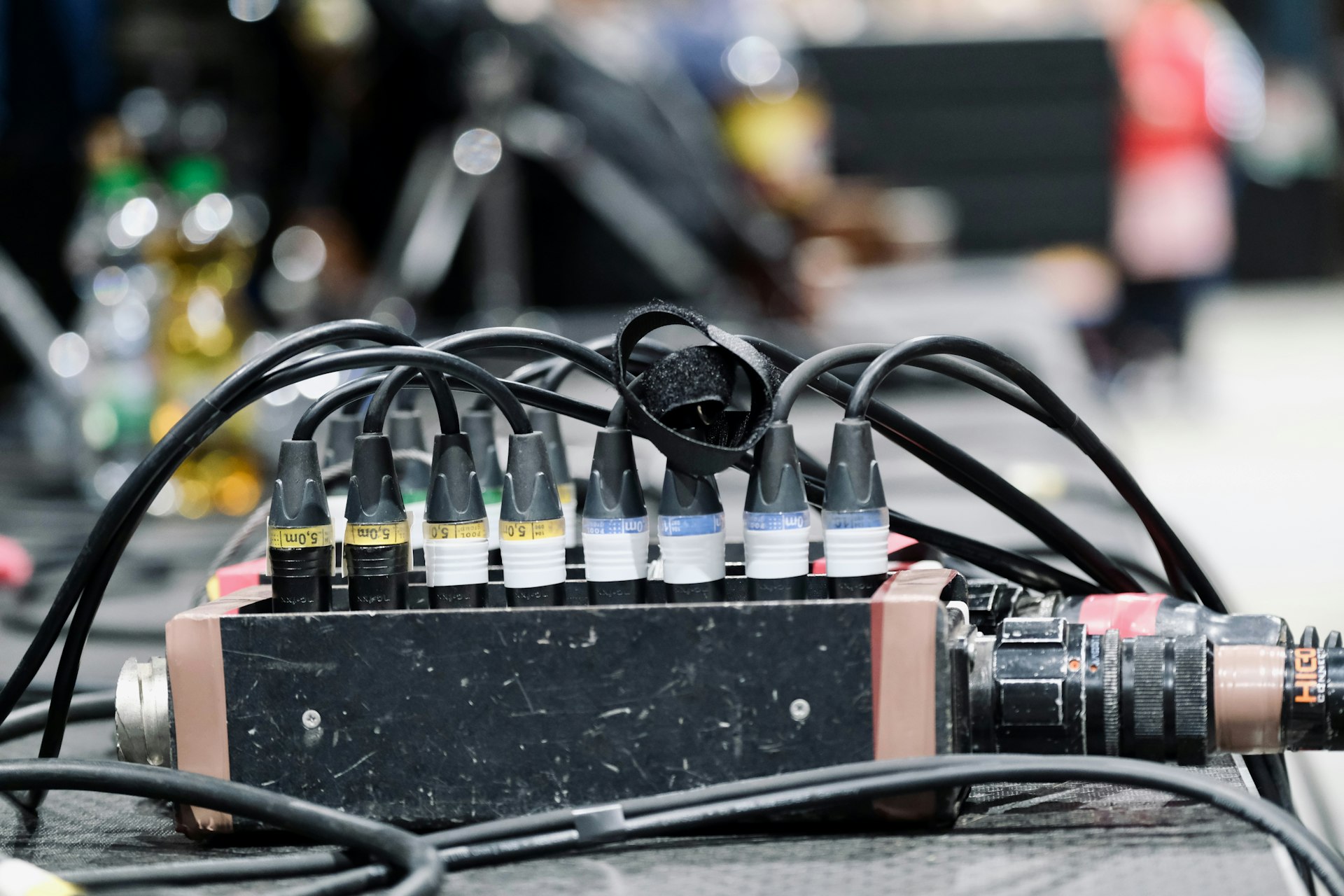 A black audio splitter box with many cables connected