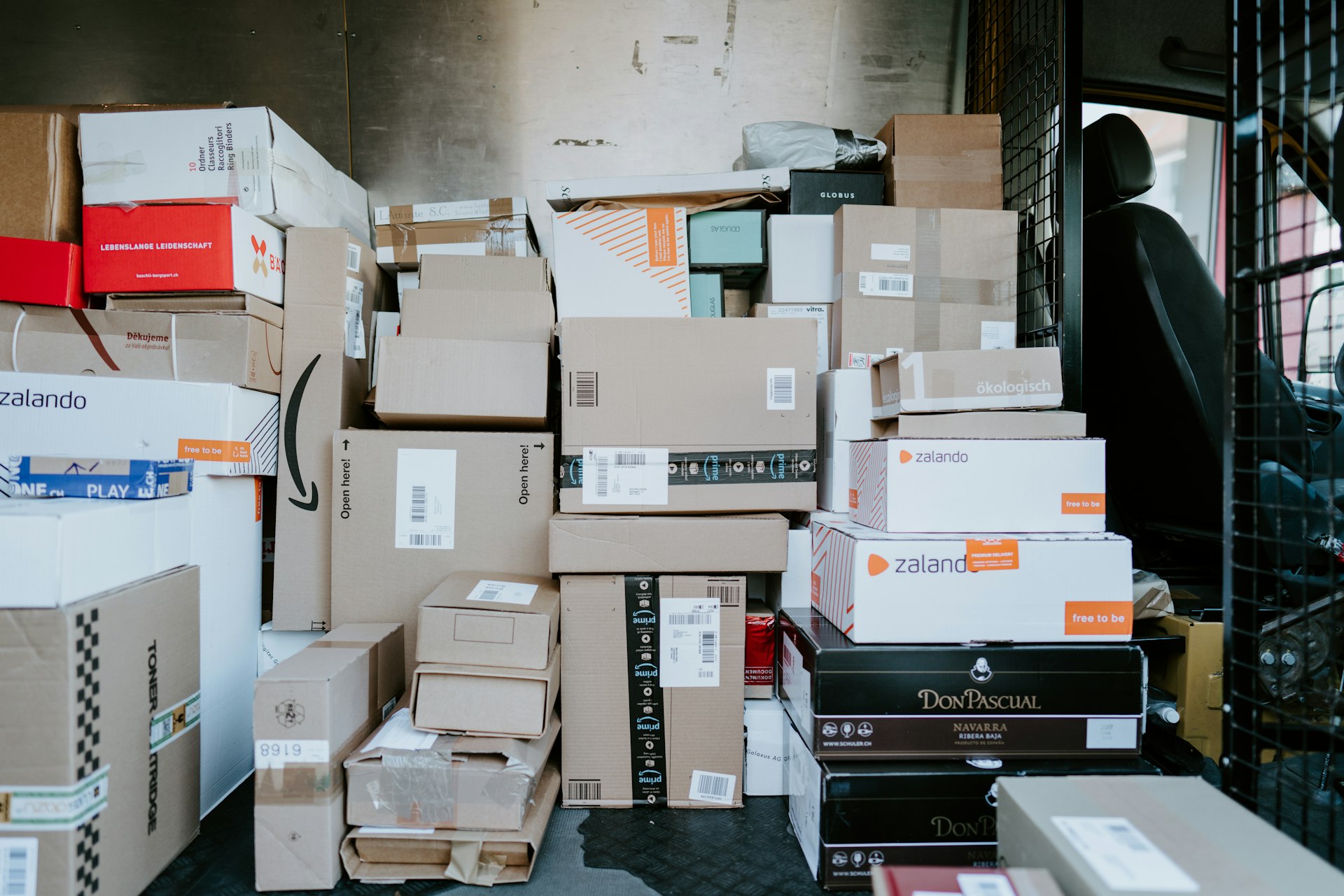 A stack of cardboard shipping boxes inside the back of a delivery van