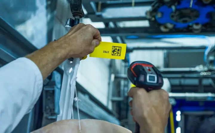 QR-code op voedselveilig sleufetiket wordt gescand in slachterij